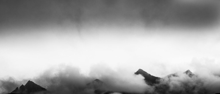 black and white mountain in the clouds